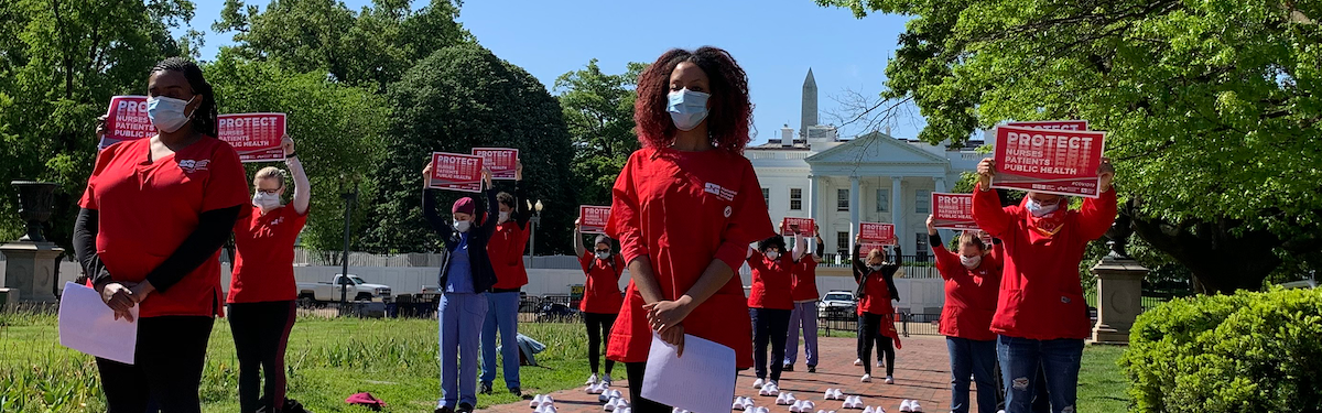 Nurses hold signs "Protect nurses, patients, and public health"