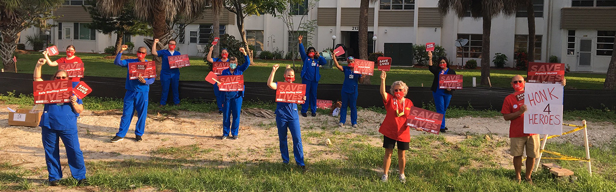 Nurses hold fists and signs