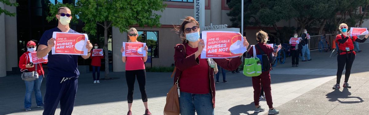 Nurses hold signs "PPE is disposable, nurses are not"