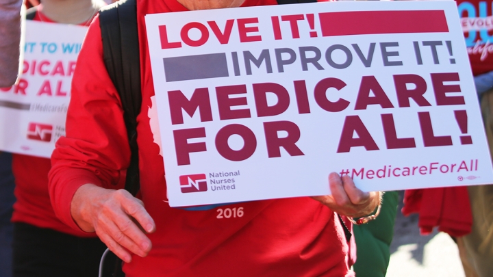 Person holding sign: "Love it, improve it, Medicare for All!"