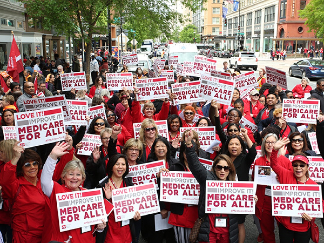 Large group of nurses hold signs for Medicare for All