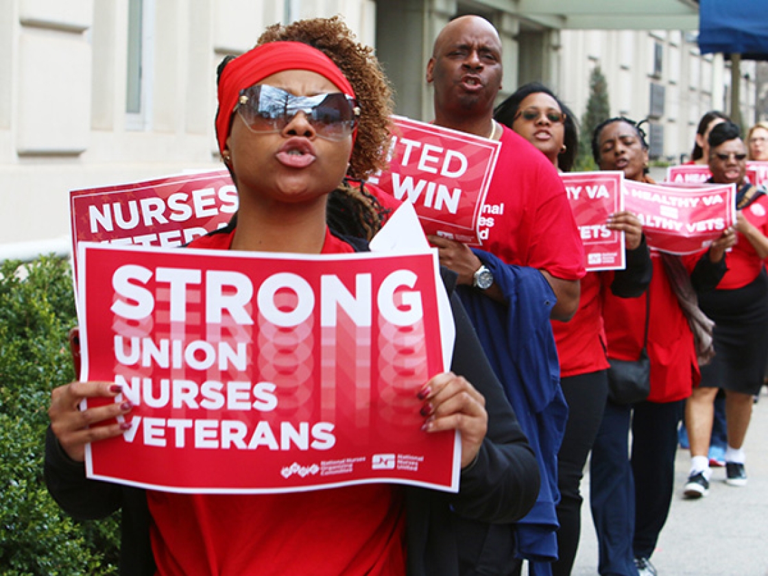 Nurses outside hold signs "Strong Union, Nurses, Veterans"