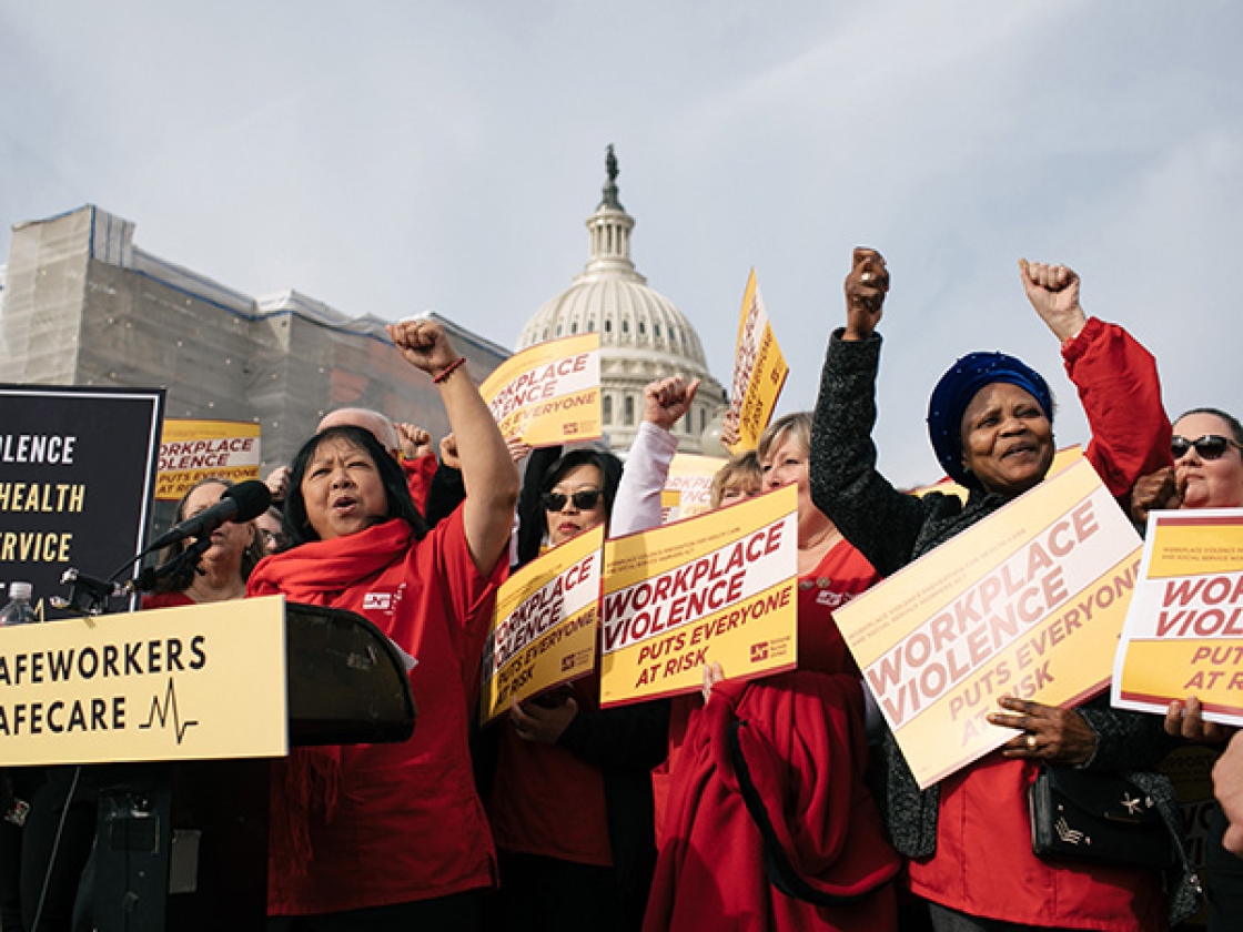 Nurses outside Capitol building hold signs calling for workplace safety