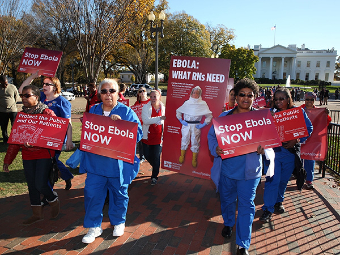Nurses outside The Whitehouse hold signs "Stop Ebola Now"