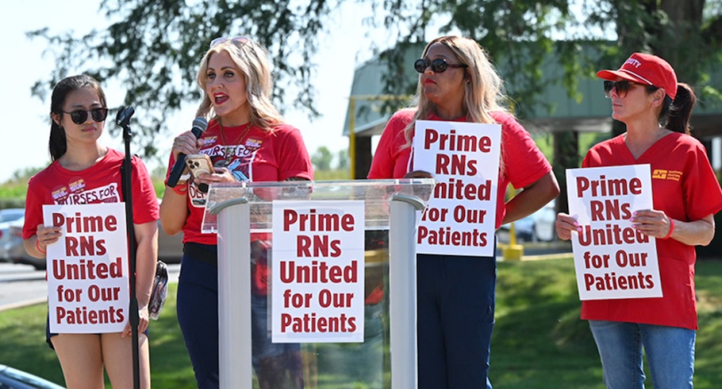 Nurses at podium behind signs "Prime RNs United for our Patients"