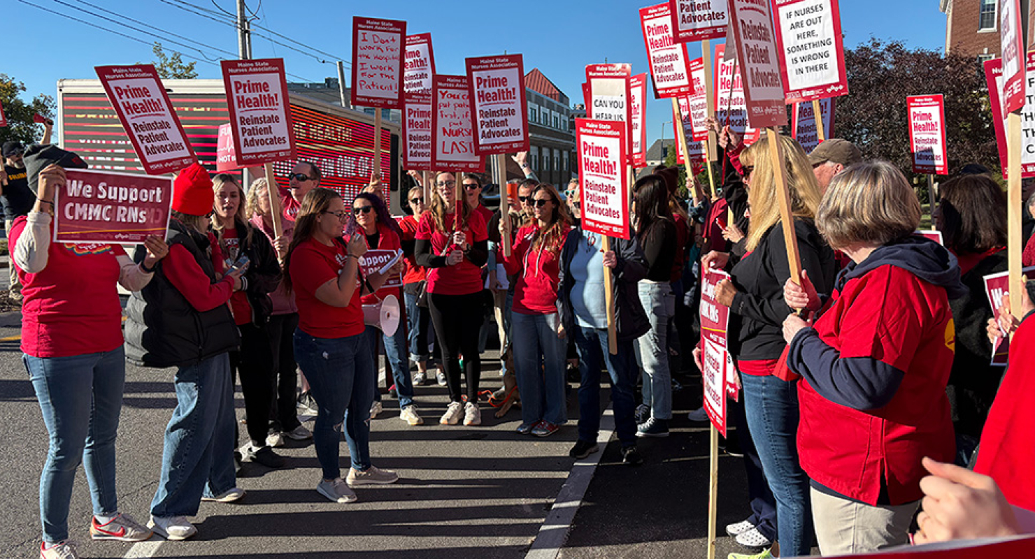 Large group of nurses rallying holding signs "Prime Health: Reinstate Patient Advocates"