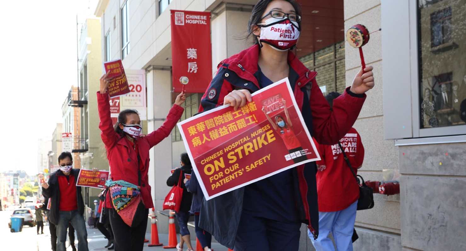Nurses outside hospital hold strike signs