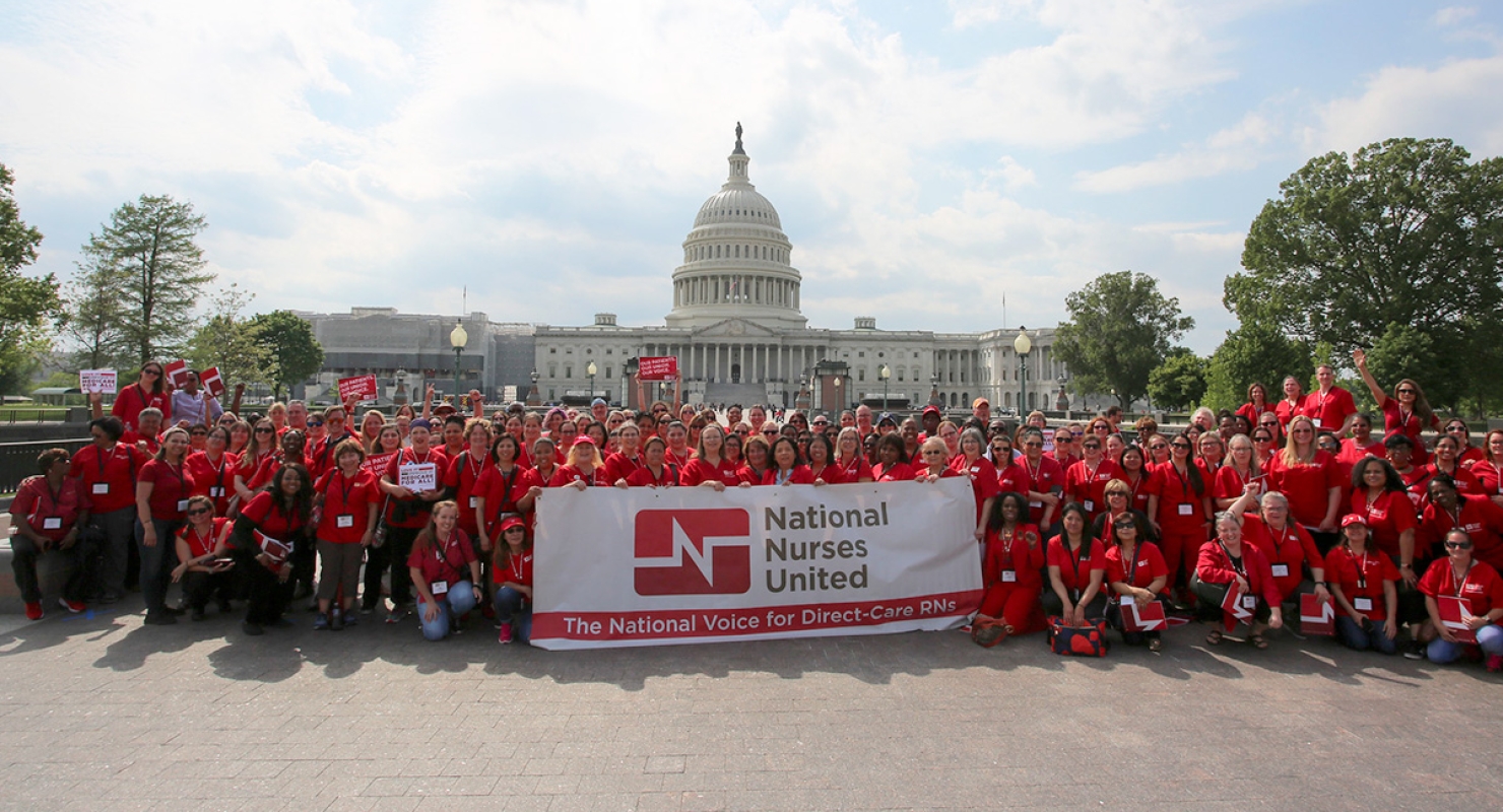Large group of nurses outside Capitol Building with National Nurses United banner