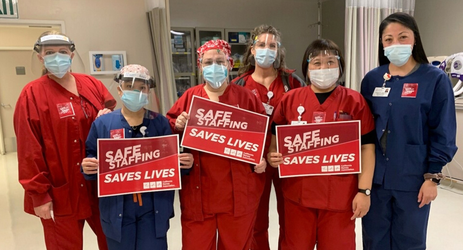 Nurses hold signs calling for safe staffing