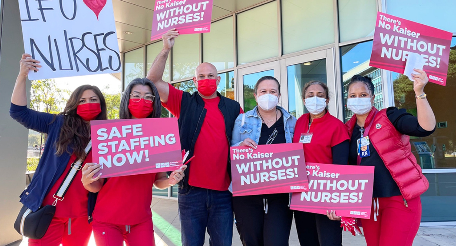 Kaiser nurses holding signs "Safe staffing now!" and "There's no Kaiser without nurses!"