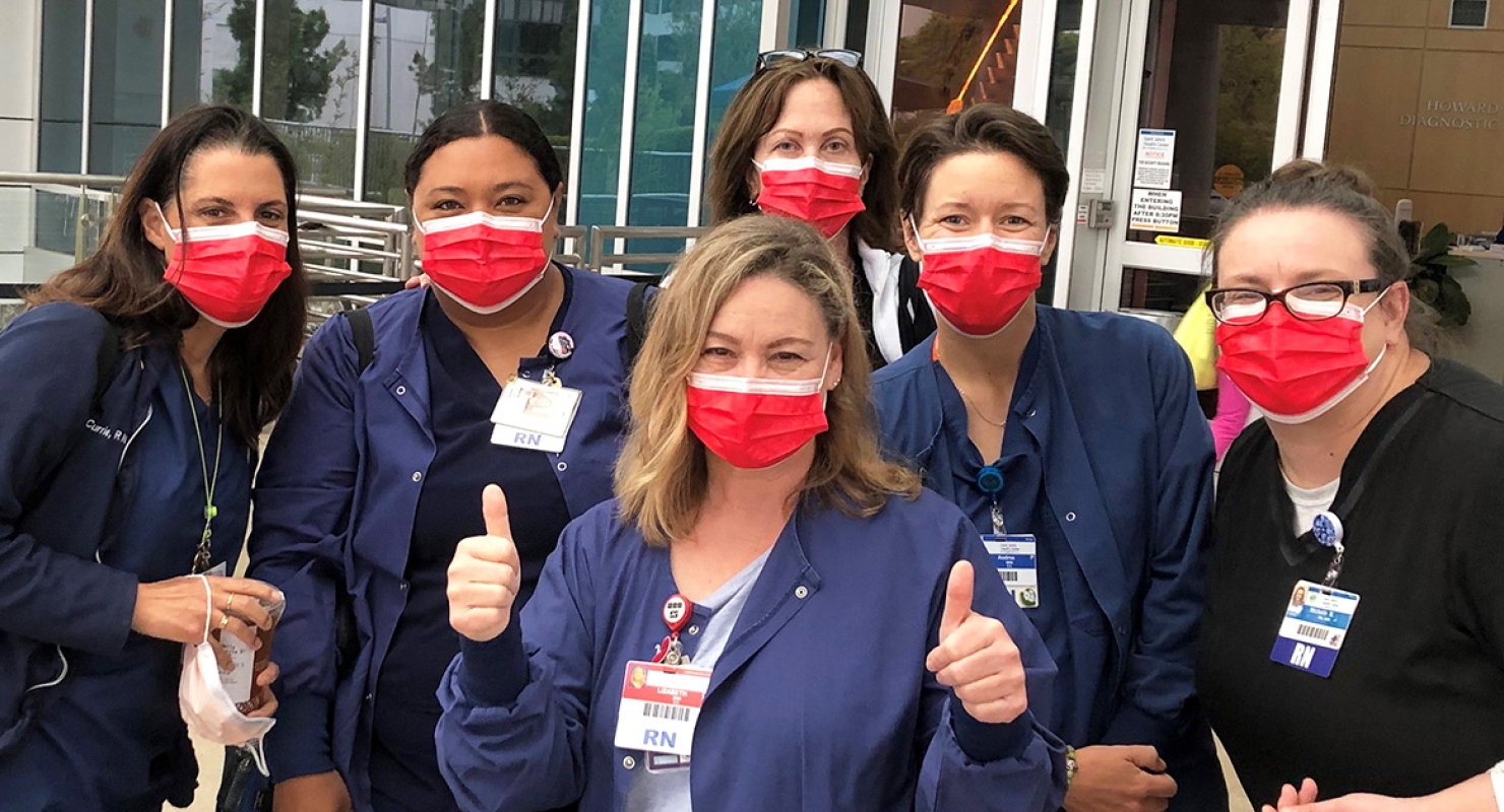 Group of nurses outside hospital with thumbs up