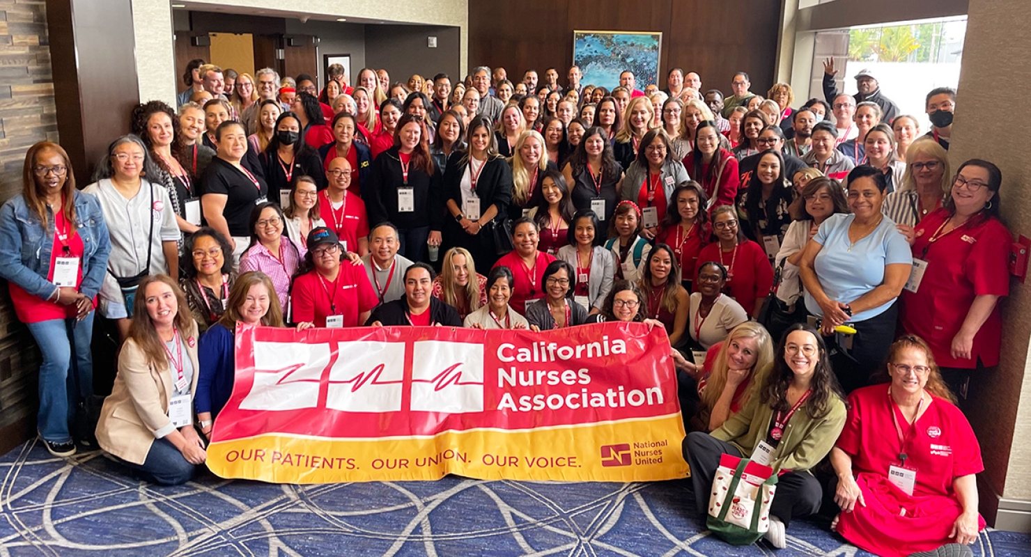 Large group of nurses inside holding banner "California Nurses Association"