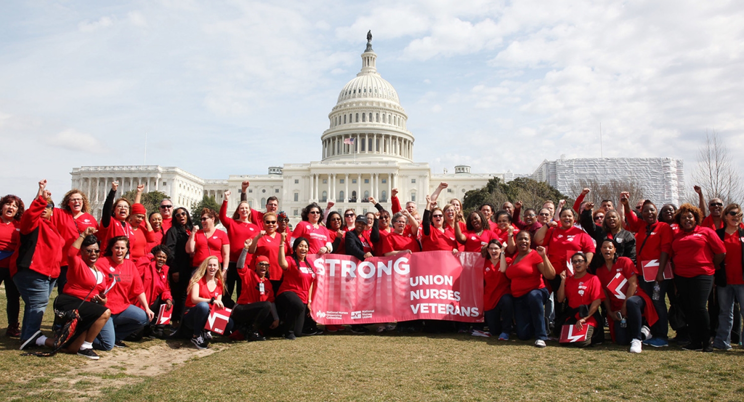 Large group of VA nurses outside U.S. capitol building holding banner
