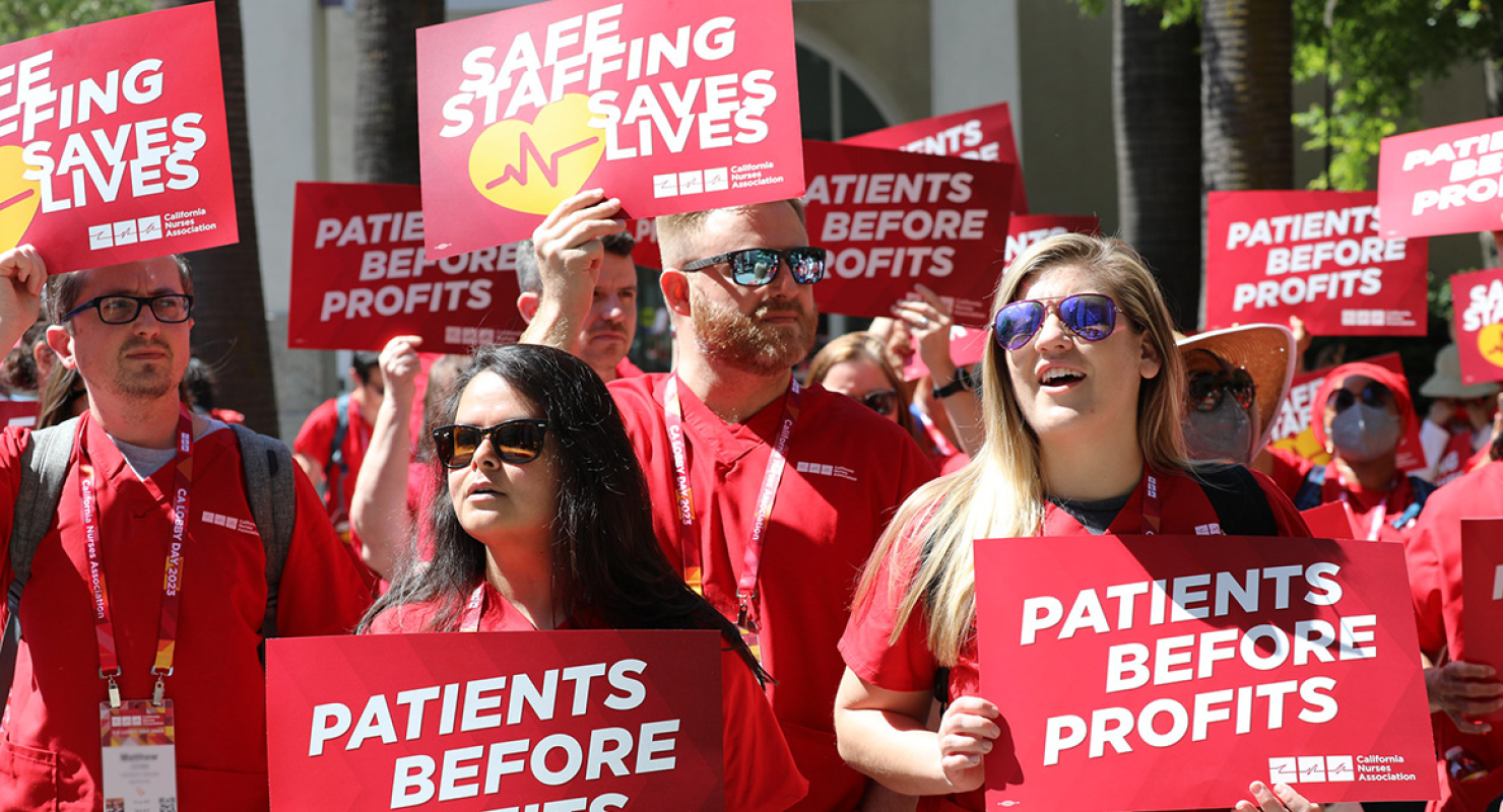 Nurses holding signs "Safe Staffing Saves Lives"