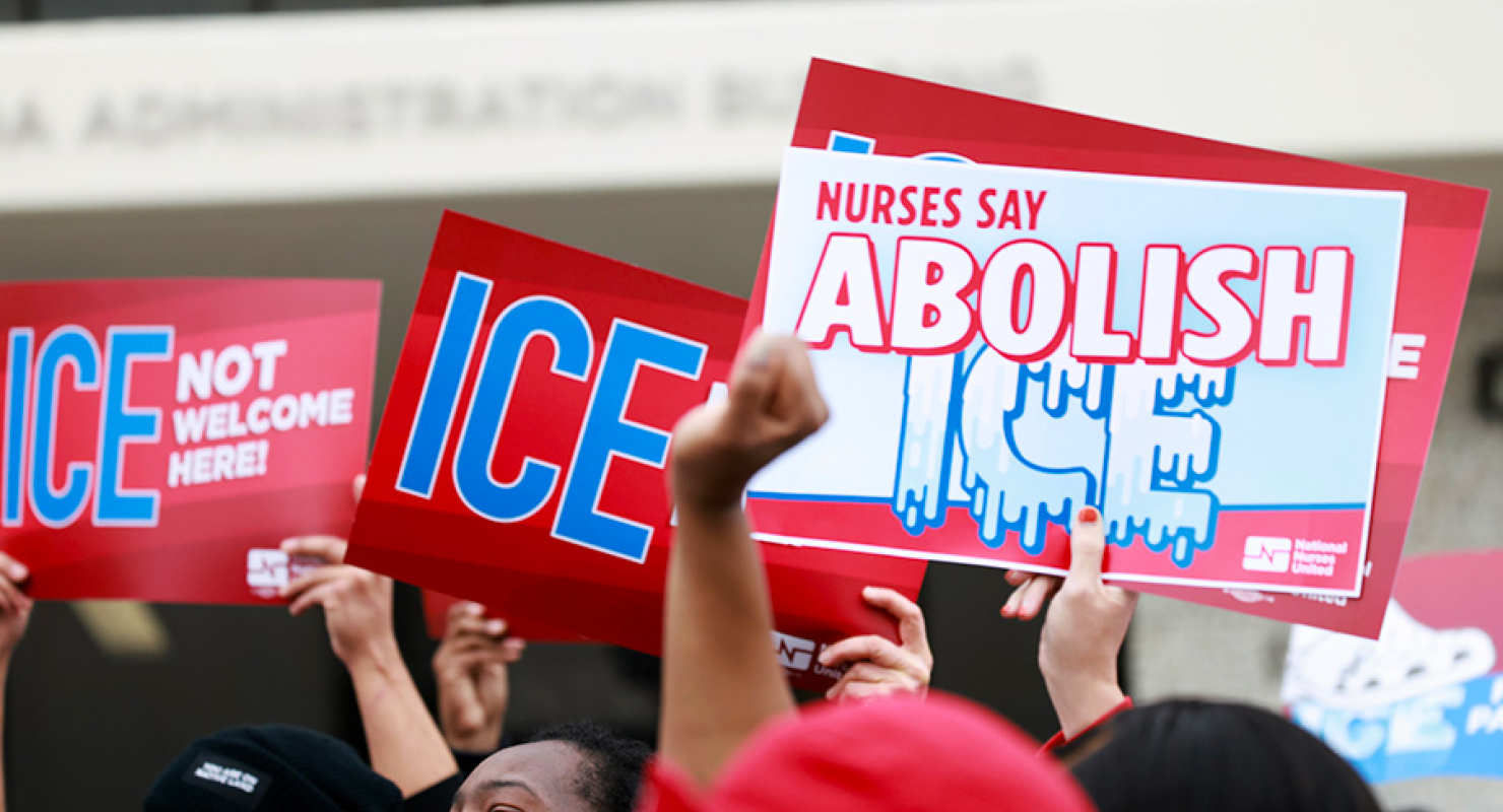 Hands holding signs "ICE not welcome here" and "Abolish ICE"