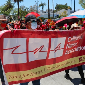 Group of nurses marching behind banner "California Nurses Association"