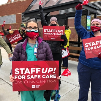 Nurses hold signs