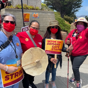 Nurses outside Seton Medical Center hold signs "Seton RNs Demand Safe Staffing"