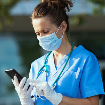 Frustrated nurse looking at smart phone