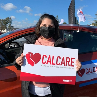 Woman outside holds CalCare sign