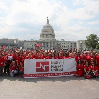 Large group of nurses outside Capitol Building with National Nurses United banner