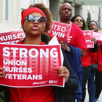 Nurses outside hold signs "Strong Union, Nurses, Veterans"