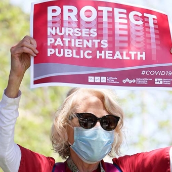 Nurse holds sign "Protect Nurses Patients Public Health