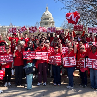 Large group of nurses outside Capitol building in Washington, D.C., holding signs "Fun Care, Not Billionaires" and "Some Cuts Don't Heal"
