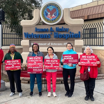 Five nurses outside in front of sign "James A. Haley Veterans Hospital" holding signs "A Healthy VA = Healthy Vets"