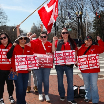 Nurses holding signs "Some Cuts Don't Heal"