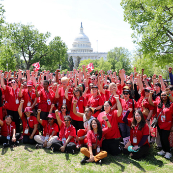 Large group of nurses outside Capitol Building in Washington, D.C.with raised fists
