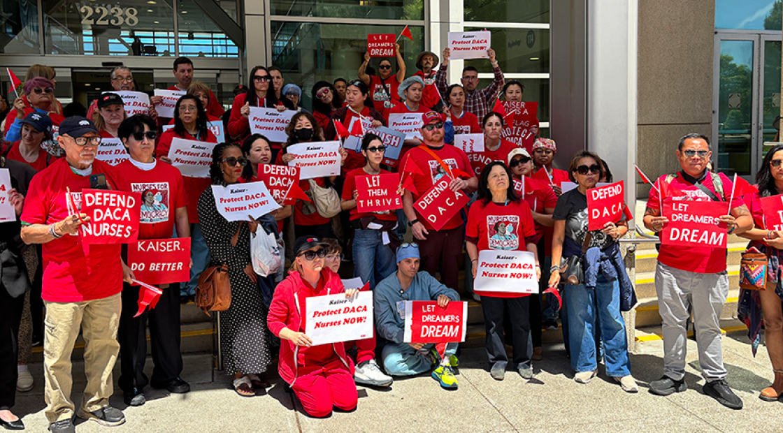 Large group of nurses outside hospital holding signs "Defend DACA Nurses" and "Protect DACA Nurses Now!"