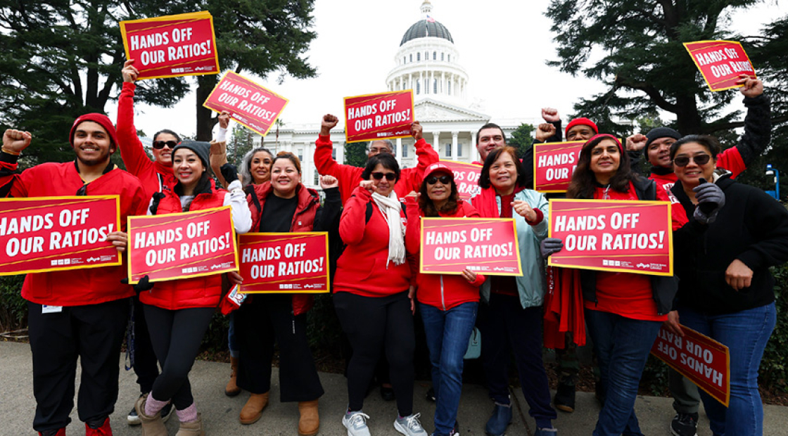 Group of nurses outside California State Capitol building holding signs "Hands Off Our Ratios"