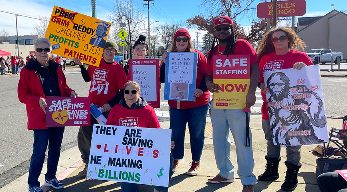 Nurses on strike line holding signs