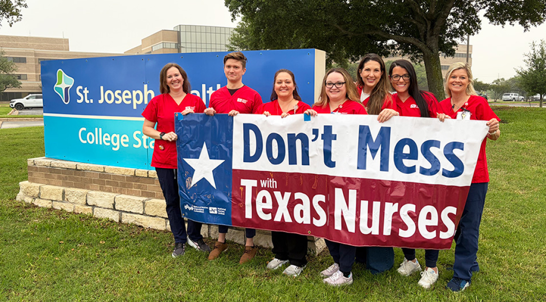 Group of nurses outside St. Joseph Health holding banner "Don't Mess With Texas Nurses"