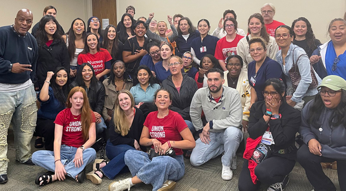 Large group of nurses inside hospital meeting room smiling