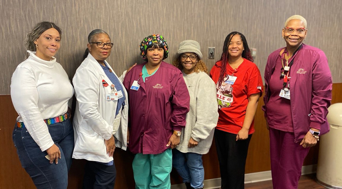 Group of six nurses, side-by-side, smiling