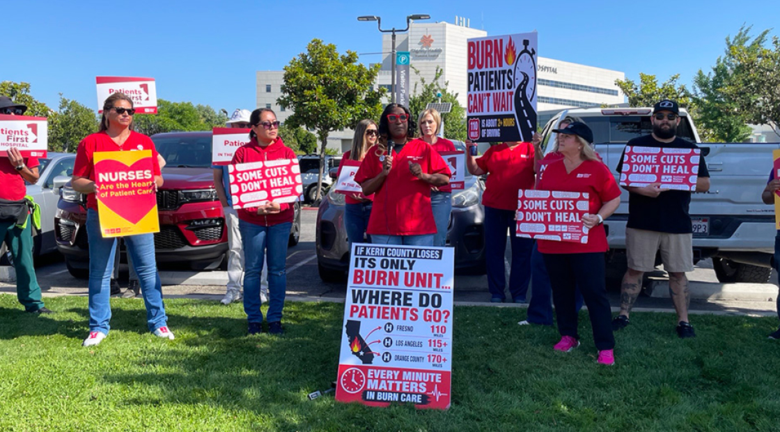 Nurses outside holding signs calling a halt of burn unit closure