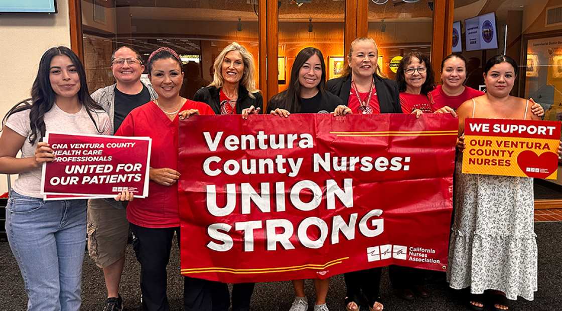 Group of nurses inside, smiling, holding banner "Ventura County Nurses: Union Strong"