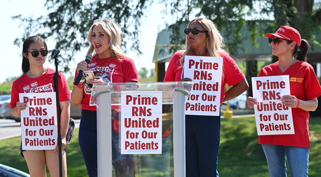 Nurses at podium behind signs "Prime RNs United for our Patients"
