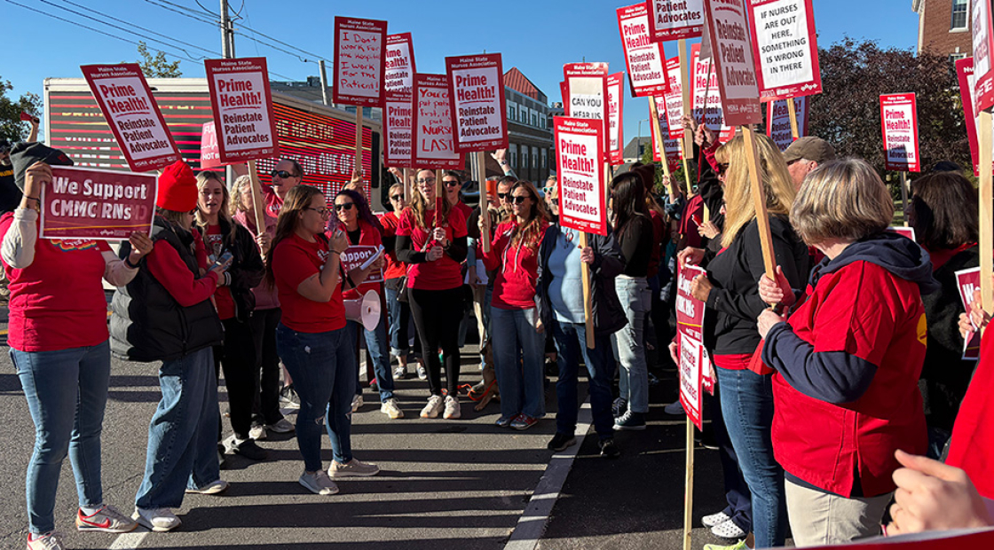 Large group of nurses rallying holding signs "Prime Health: Reinstate Patient Advocates"