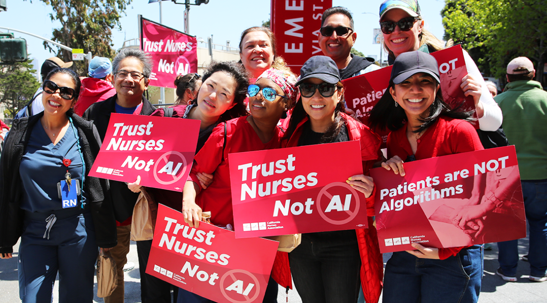 Group of nurses holding signs "Trust Nurses Not A.I." and "Patients are NOT algorithms"