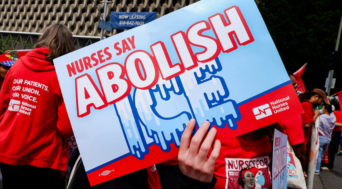 Hand holding signs "Nurses Say Abolish ICE"