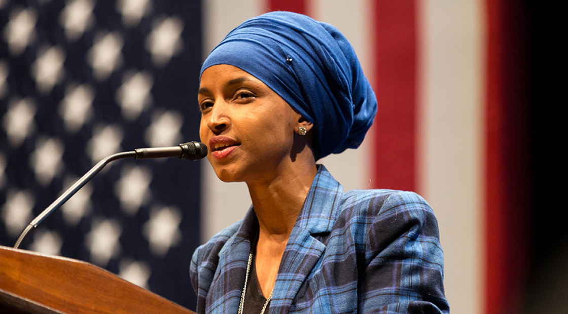Rep. Ilhan Omar at podium in front of American flag