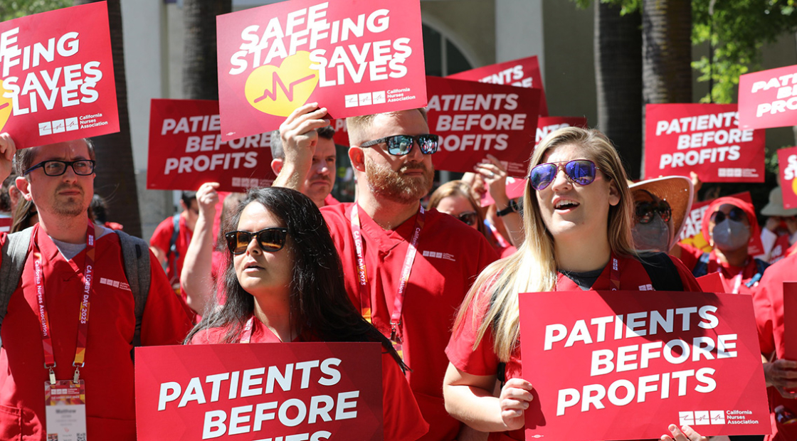 Nurses outside holding signs "Patients Before Profits" and "Safe Staffing Saves Lives"