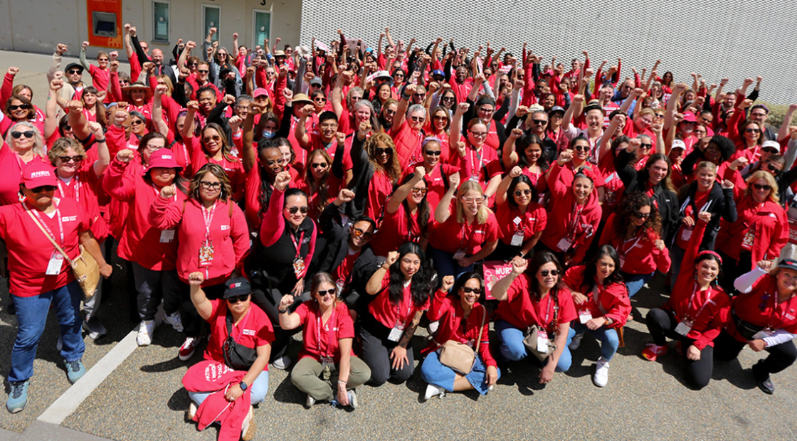 Large group of nurses with raised fists