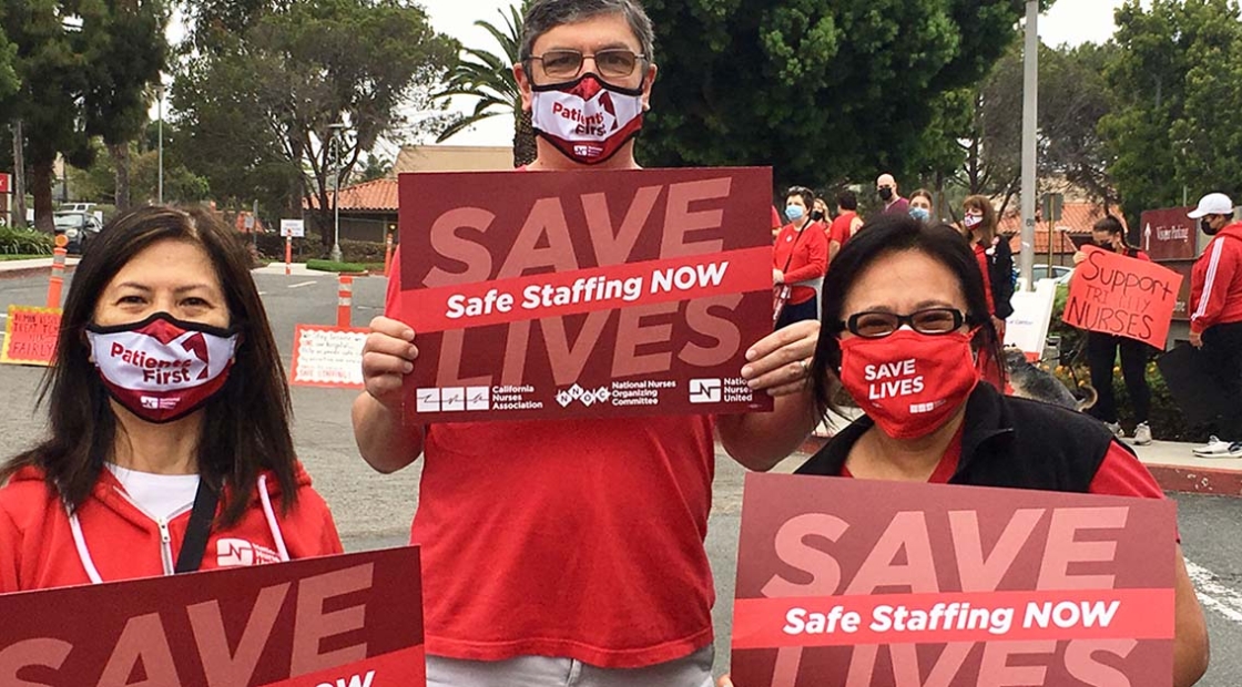 3 nurses outside hold signs "Safe Staffing Now"