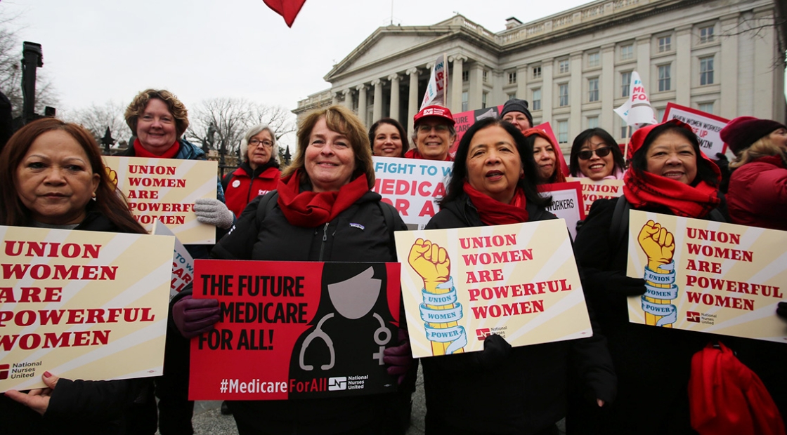 Group of nurses in march holding signs "Union women are powerful women"