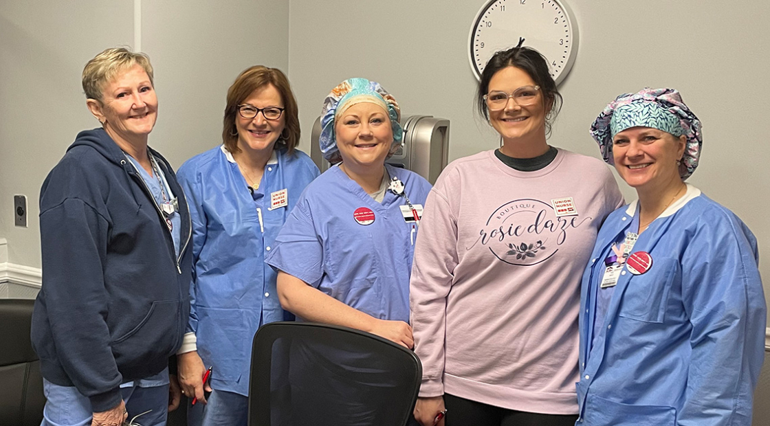 5 nurses inside hospital smiling