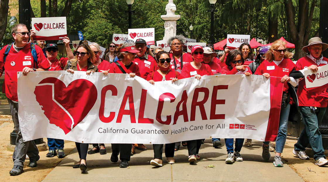 Group of nurses in scrubs marching holding "CalCare"